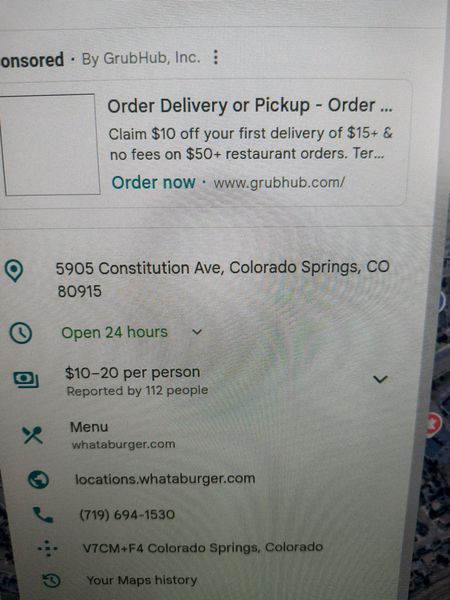 The image shows a GrubHub sponsored ad for Whataburger, located at 5905 Constitution Ave, Colorado Springs, CO 80915. The ad highlights a $10 off offer on the first delivery of $15+ and no fees on $50+ orders. The restaurant is open 24 hours and the price range is $10-20 per person, as reported by 112 people. The menu can be found at whataburger.com, and the location is also listed at locations.whataburger.com. The phone number provided is (719) 694-1530.